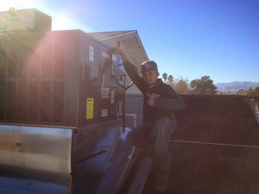 HVAC technician performing Air Duct Repair on a rooftop unit in Shasta Lake