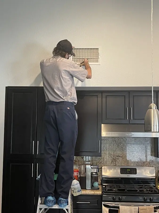 Technician inspecting an air vent during HVAC service in Shasta Lake